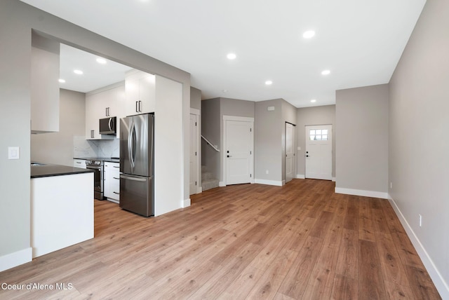 1674 Onyx Ct, Sandpoint, ID 83864 - kitchen with stainless steel appliances, dark countertops, white cabinets, light wood finished floors, and recessed lighting