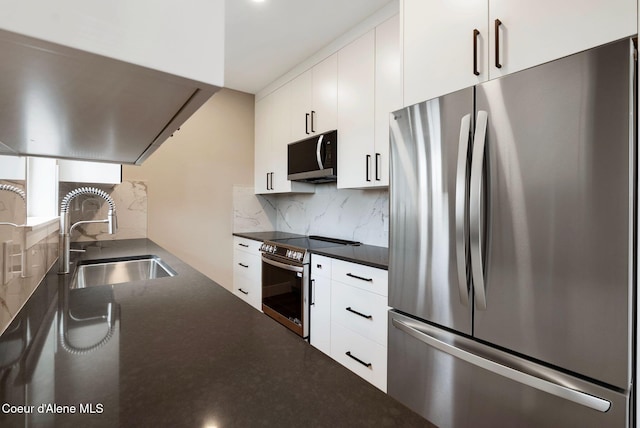 1674 Onyx Ct, Sandpoint, ID 83864 - kitchen featuring appliances with stainless steel finishes, a sink, dark countertops, tasteful backsplash, and white cabinets