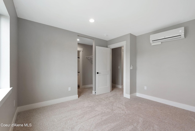 1674 Onyx Ct, Sandpoint, ID 83864 - unfurnished bedroom featuring a wall mounted AC, light carpet, baseboards, a spacious closet, and recessed lighting