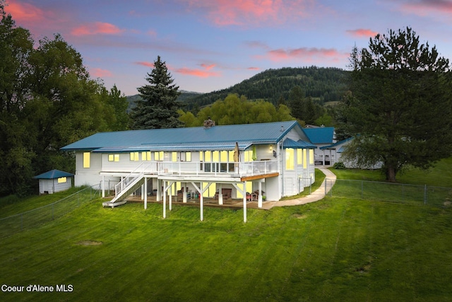 291 Comeback Bay Ln, Sagle, ID 83860 - back of house at dusk featuring stairway, a deck with mountain view, metal roof, and a chimney