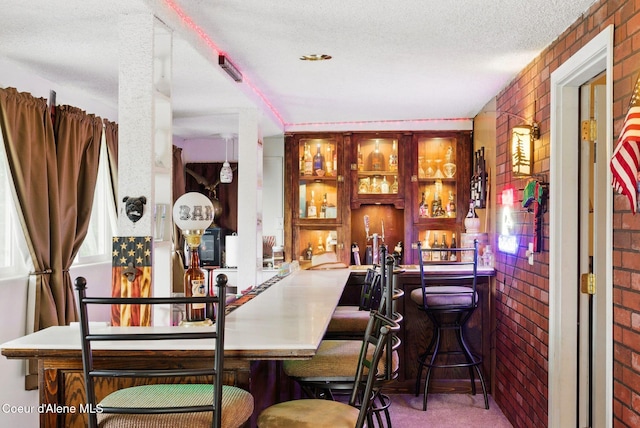 291 Comeback Bay Ln, Sagle, ID 83860 - indoor bar featuring brick wall, carpet floors, and a textured ceiling