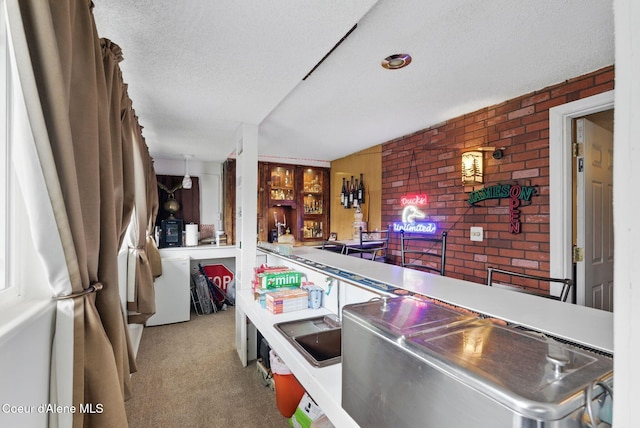 291 Comeback Bay Ln, Sagle, ID 83860 - kitchen featuring brick wall, carpet floors, and a textured ceiling