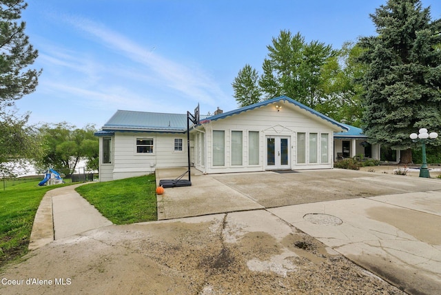 291 Comeback Bay Ln, Sagle, ID 83860 - rear view of house featuring french doors, a patio, a lawn, metal roof, and a playground