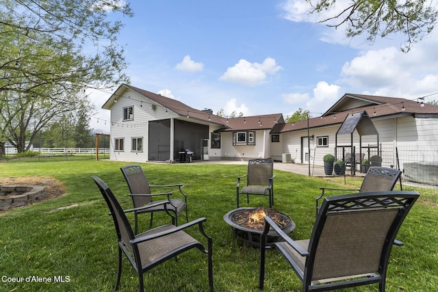 7104 W Kidd Island Rd, Coeur Dalene, ID 83814 - rear view of property featuring an outdoor fire pit, a patio area, and a sunroom