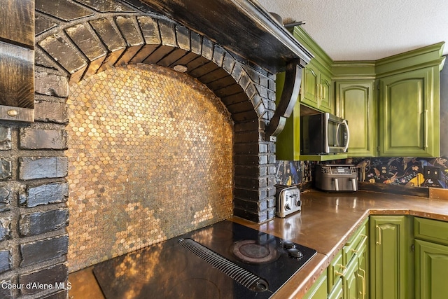 7104 W Kidd Island Rd, Coeur Dalene, ID 83814 - kitchen featuring stainless steel microwave, backsplash, a textured ceiling, and black electric stovetop