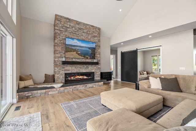 1831 E Dalton Ave, Dalton Gardens, ID 83815 - living room featuring high vaulted ceiling, a stone fireplace, wood finished floors, recessed lighting, and a barn door