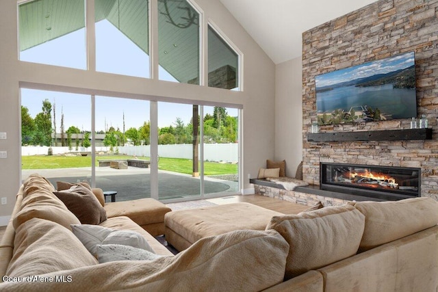 1831 E Dalton Ave, Dalton Gardens, ID 83815 - living area featuring a stone fireplace, a water view, high vaulted ceiling, baseboards, and wood finished floors