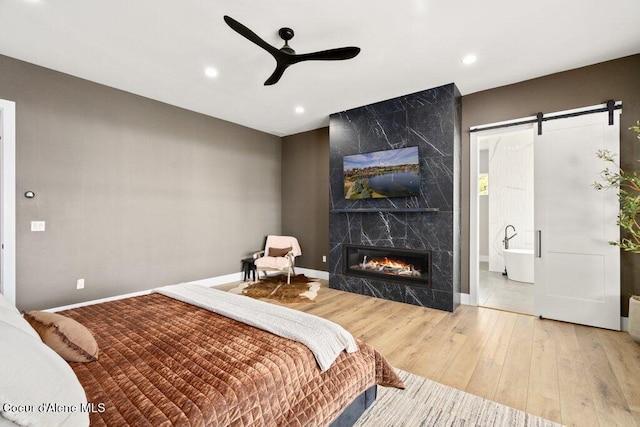 1831 E Dalton Ave, Dalton Gardens, ID 83815 - bedroom featuring wood finished floors, a high end fireplace, baseboards, a barn door, and recessed lighting