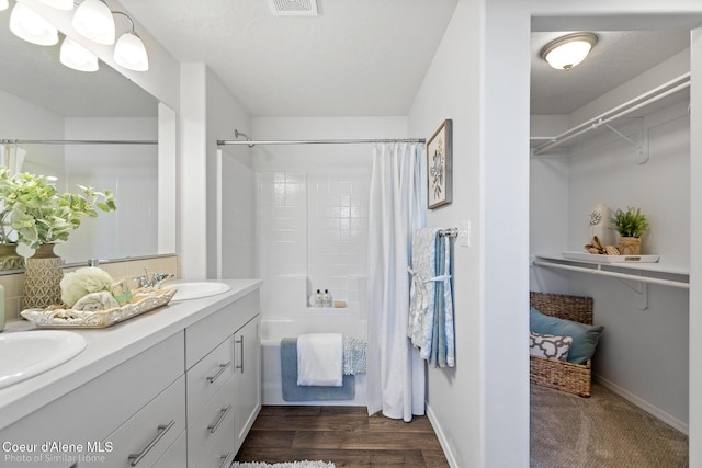 13659 N Apex Way, Hayden, ID 83835 - bathroom with double vanity, shower / bath combination with curtain, baseboards, and wood finished floors