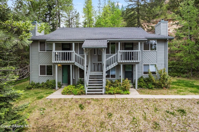 64 Winterbrook Way Unit 101, Sandpoint, ID 83864 - view of front facade featuring a chimney, stairway, a front yard, and roof with shingles