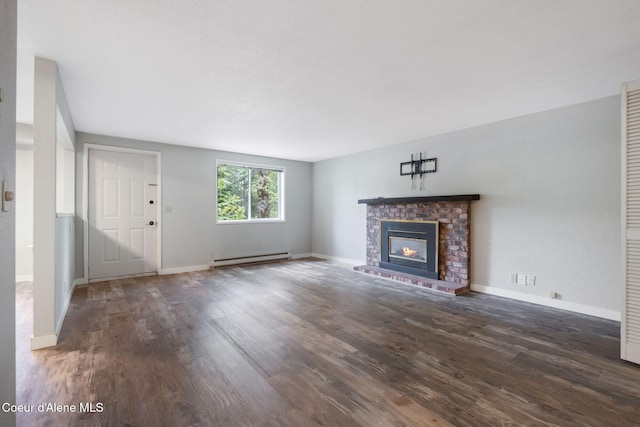 64 Winterbrook Way Unit 101, Sandpoint, ID 83864 - unfurnished living room featuring wood finished floors, a baseboard radiator, a fireplace, and baseboards