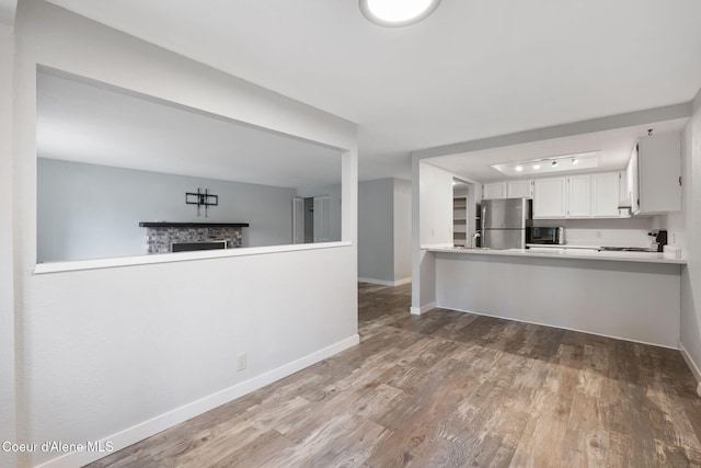 64 Winterbrook Way Unit 101, Sandpoint, ID 83864 - kitchen featuring appliances with stainless steel finishes, wood finished floors, baseboards, light countertops, and white cabinetry