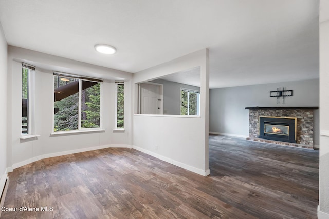 64 Winterbrook Way Unit 101, Sandpoint, ID 83864 - unfurnished living room featuring wood finished floors, baseboards, a fireplace, and a baseboard radiator