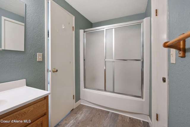 64 Winterbrook Way Unit 101, Sandpoint, ID 83864 - full bathroom with wood finished floors, vanity, a textured wall, and enclosed tub / shower combo