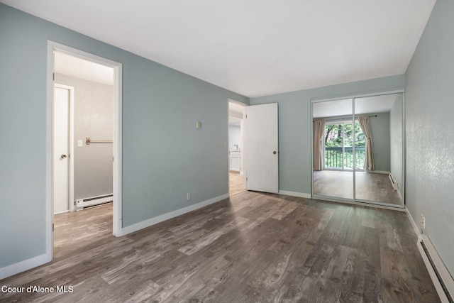64 Winterbrook Way Unit 101, Sandpoint, ID 83864 - unfurnished bedroom featuring a baseboard radiator, wood finished floors, and baseboards