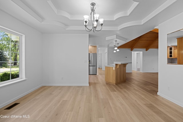 2411 W Diamond Bar Rd, Rathdrum, ID 83858 - kitchen featuring stainless steel fridge, a chandelier, open floor plan, a tray ceiling, and a breakfast bar area