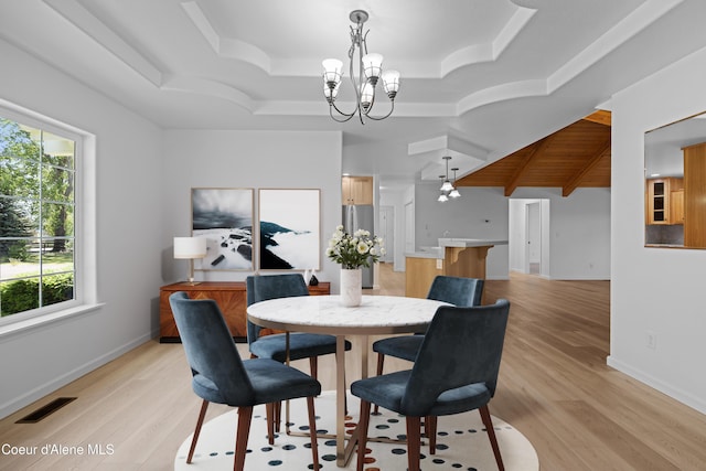 2411 W Diamond Bar Rd, Rathdrum, ID 83858 - dining room featuring a chandelier, light wood-type flooring, and a tray ceiling