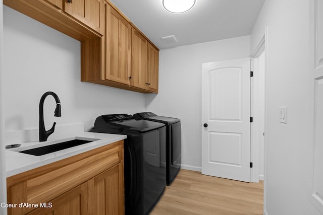 2411 W Diamond Bar Rd, Rathdrum, ID 83858 - washroom with washing machine and dryer, light wood-style flooring, and cabinet space