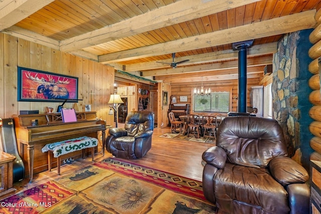 1180 Mountain View Rd, Clark Fork, ID 83811 - living area with rustic walls, a wood stove, wood finished floors, wood ceiling with exposed beams, and a chandelier