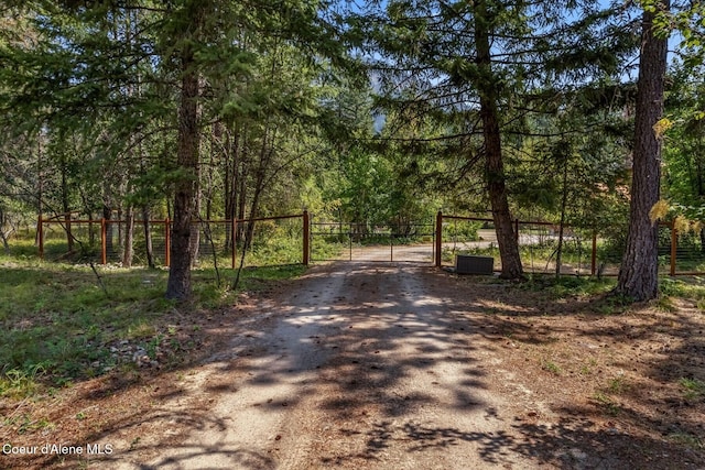 1180 Mountain View Rd, Clark Fork, ID 83811 - view of dirt / gravel road with a gate and a view of trees