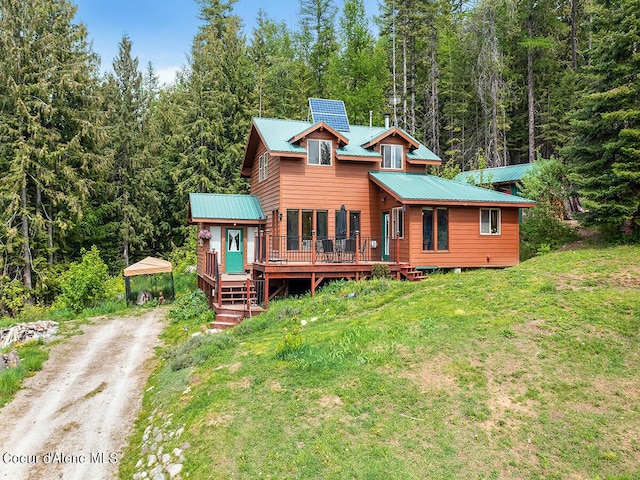 1155 Gold Creek Ridge Rd, Sandpoint, ID 83864 - rustic home with a view of trees, a deck, metal roof, and driveway
