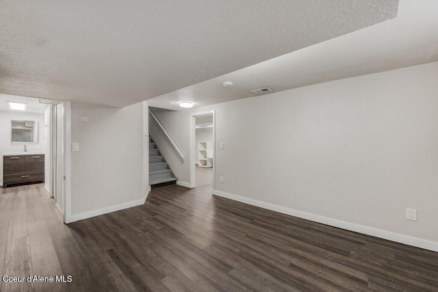 1415 N 2nd St, Coeur Dalene, ID 83814 - unfurnished living room featuring wood finished floors, baseboards, stairs, and a textured ceiling