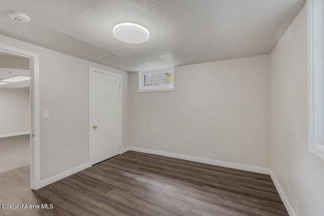 1415 N 2nd St, Coeur Dalene, ID 83814 - unfurnished bedroom featuring dark wood finished floors, a textured ceiling, and baseboards