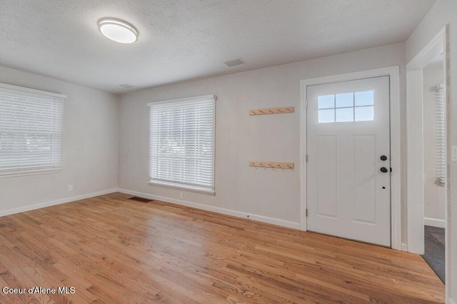 1415 N 2nd St, Coeur Dalene, ID 83814 - foyer entrance featuring light wood finished floors, baseboards, and a textured ceiling