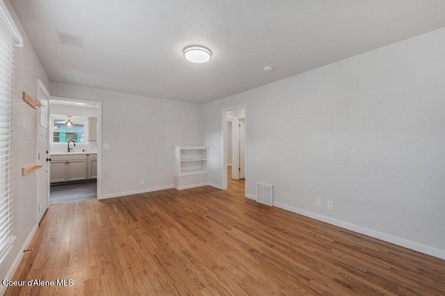 1415 N 2nd St, Coeur Dalene, ID 83814 - unfurnished bedroom featuring light wood-style flooring, baseboards, and a sink