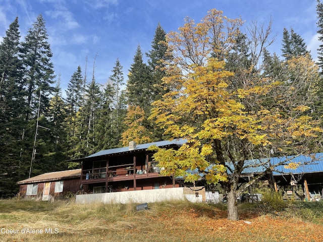 1728 Dry Creek Rd, Clark Fork, ID 83811 - rear view of property with a forest view, a chimney, and metal roof