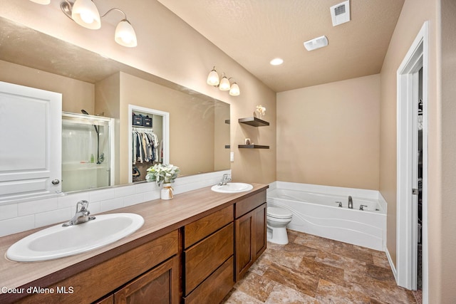 13311 N Loveland Way, Hayden, ID 83835 - bathroom featuring stone finish flooring, a walk in closet, a bath, a stall shower, and double vanity