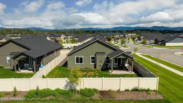 13311 N Loveland Way, Hayden, ID 83835 - back of house featuring board and batten siding, a residential view, a mountain view, and a patio