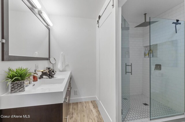 2840 W Masters Dr, Coeur Dalene, ID 83815 - full bath with double vanity, a stall shower, wood finished floors, and baseboards