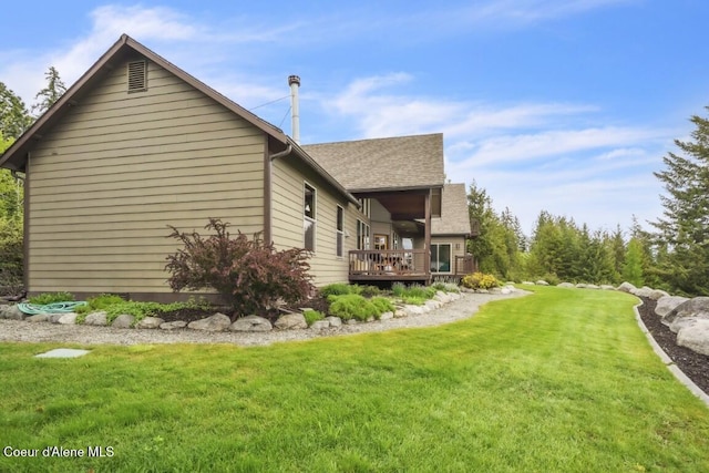 558 Grouse Hill Rd, Bonners Ferry, ID 83805 - view of side of home with a lawn, a deck, and a shingled roof