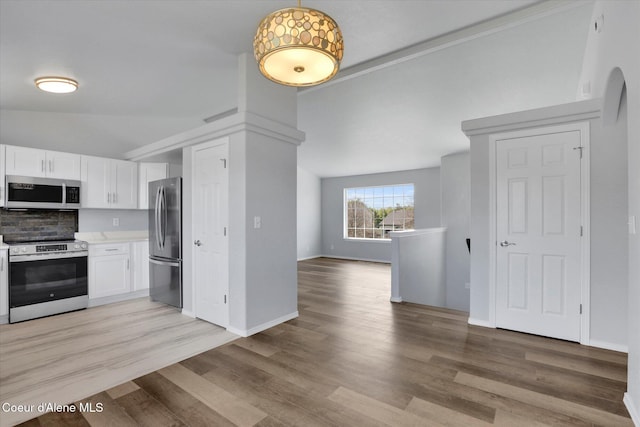 2230 N Methow Ct, Post Falls, ID 83854 - kitchen featuring stainless steel appliances, vaulted ceiling, white cabinets, light countertops, and backsplash