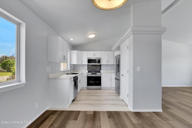 2230 N Methow Ct, Post Falls, ID 83854 - kitchen featuring stainless steel appliances, a sink, lofted ceiling, healthy amount of natural light, and light countertops