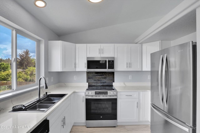 2230 N Methow Ct, Post Falls, ID 83854 - kitchen featuring stainless steel appliances, plenty of natural light, white cabinets, vaulted ceiling, and a sink