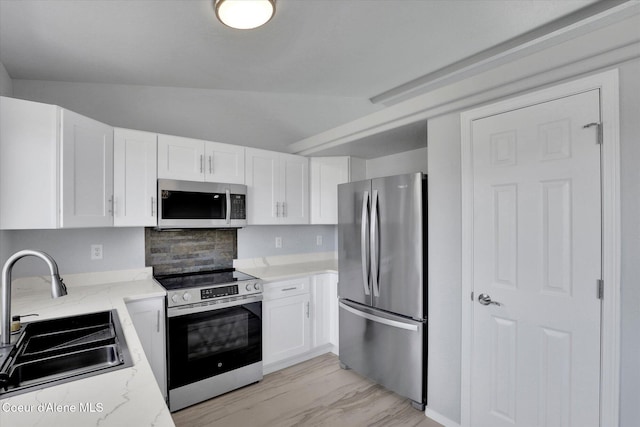 2230 N Methow Ct, Post Falls, ID 83854 - kitchen with stainless steel appliances, a sink, light stone countertops, white cabinetry, and lofted ceiling