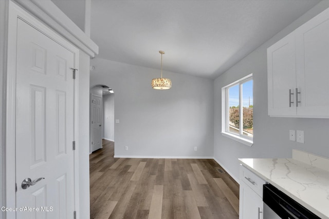 2230 N Methow Ct, Post Falls, ID 83854 - unfurnished dining area with arched walkways, wood finished floors, baseboards, and lofted ceiling