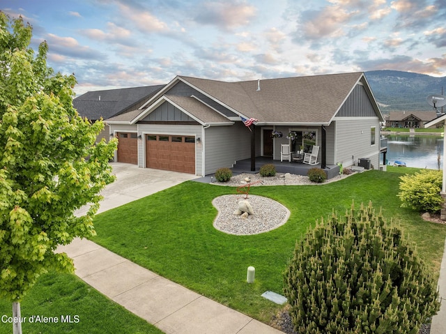 14441 N Pristine Cir, Rathdrum, ID 83858 - view of front of home with board and batten siding, a garage, covered porch, a front lawn, and driveway