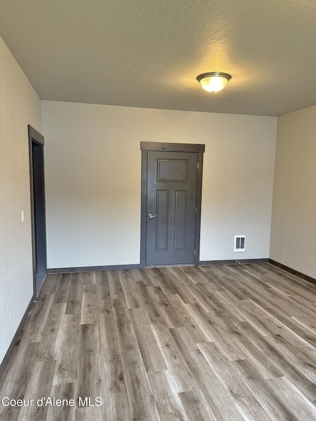 14441 N Pristine Cir, Rathdrum, ID 83858 - spare room with wood finished floors, baseboards, and a textured ceiling