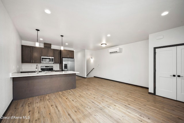 2248 N Syringa St, Post Falls, ID 83854 - kitchen with stainless steel appliances, a wall mounted air conditioner, dark brown cabinets, a sink, and a peninsula