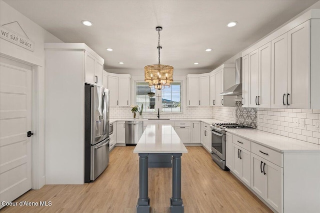 2917 N Bygone Way, Post Falls, ID 83854 - kitchen featuring stainless steel appliances, wall chimney range hood, a sink, light countertops, and a chandelier