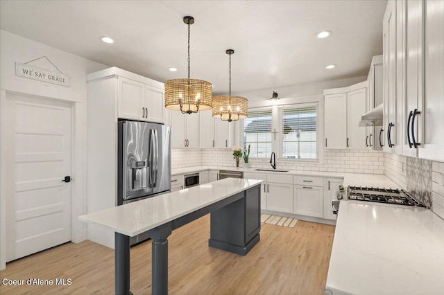 2917 N Bygone Way, Post Falls, ID 83854 - kitchen featuring a sink, a chandelier, tasteful backsplash, a breakfast bar area, and appliances with stainless steel finishes