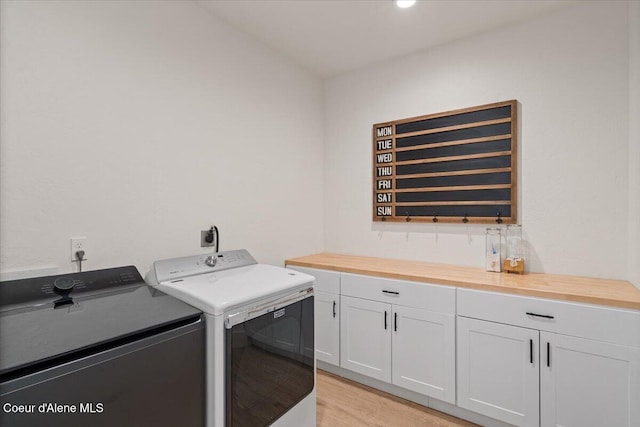 2917 N Bygone Way, Post Falls, ID 83854 - laundry room featuring washer and dryer, cabinet space, and light wood finished floors