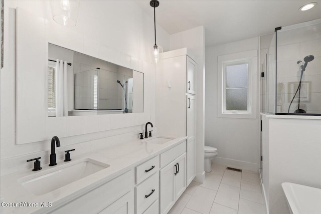 2917 N Bygone Way, Post Falls, ID 83854 - bathroom with double vanity, a tile shower, toilet, baseboards, and a freestanding bath