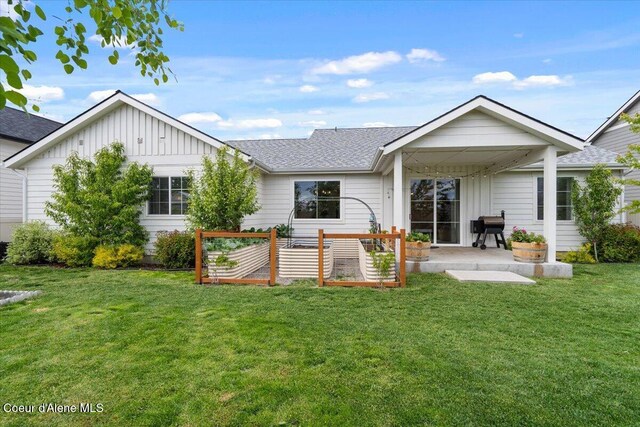 2917 N Bygone Way, Post Falls, ID 83854 - back of house with board and batten siding, a patio area, a lawn, and roof with shingles
