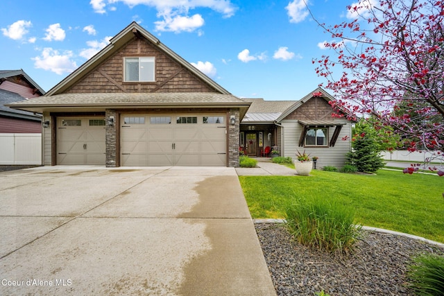 1044 E Maroon Creek Dr, Hayden, ID 83835 - craftsman-style house featuring a front lawn, concrete driveway, roof with shingles, stone siding, and an attached garage
