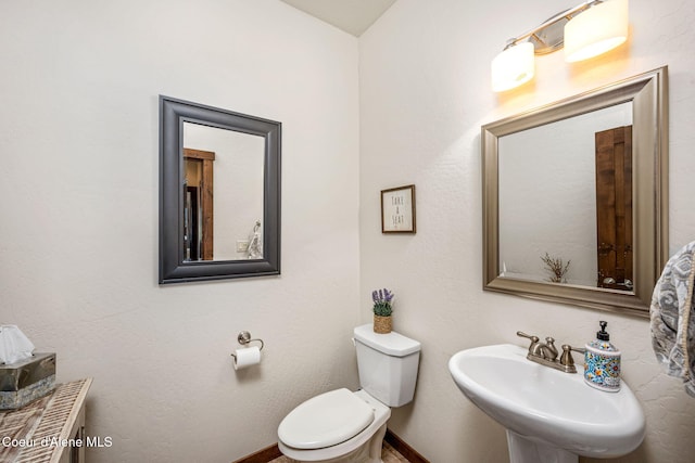 1044 E Maroon Creek Dr, Hayden, ID 83835 - bathroom featuring toilet, a sink, and baseboards