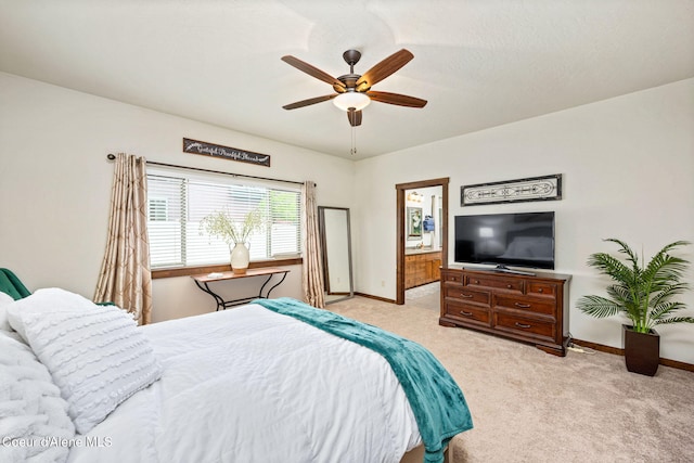 1044 E Maroon Creek Dr, Hayden, ID 83835 - bedroom featuring light colored carpet, baseboards, ceiling fan, and connected bathroom